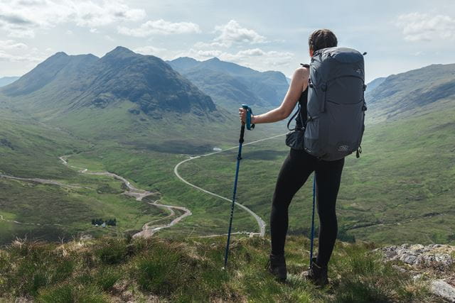 Man on hill in walking gear looking at view